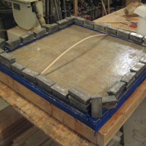 2016 03 05 LazaretteHatch 003  Laminating the bottom skin, fiberglas roving in epoxy.  The spring stick and the ballast force the perimeter tight to t