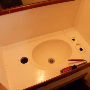 The original little shallow sink. Non-functioning hand pump on the left.  Drain plug lost.  Faucet on the right.
