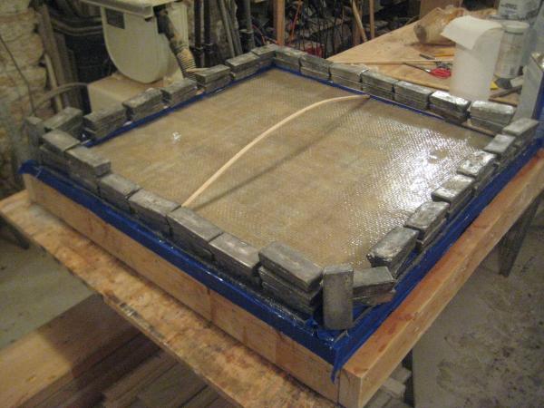 2016 03 05 LazaretteHatch 003  Laminating the bottom skin, fiberglas roving in epoxy.  The spring stick and the ballast force the perimeter tight to t