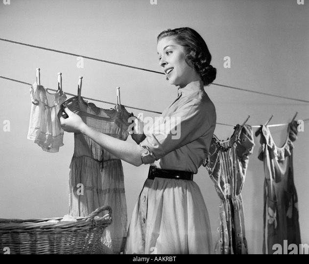 1950s-smiling-woman-housewife-hanging-wash-on-clothesline-to-dry-aakrbt.jpg