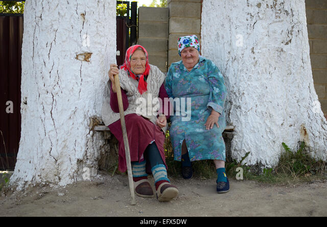 portrait-of-two-old-russian-women-sitting-near-house-between-two-an-efx5dw.jpg