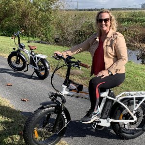 Wife and I on electric bikes with gator in the background