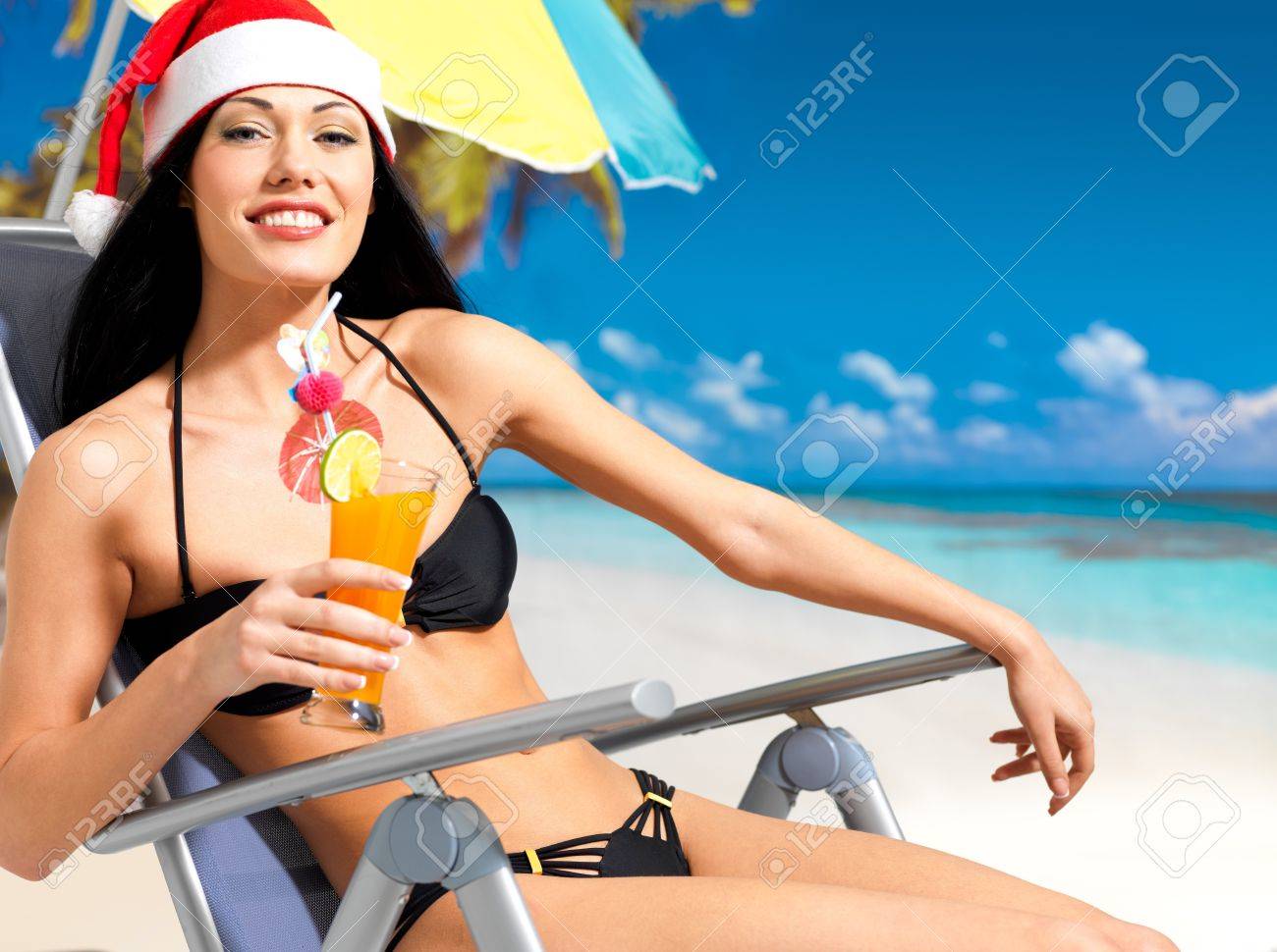40659300-Happy-woman-celebrating-the-new-year-at-the-beach-A-beautiful-girl-in-the-santa-hat-with-a-refreshin-Stock-Photo.jpg